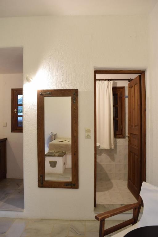 a mirror on the wall of a room with a bed at Sunset Pounda in Pounda