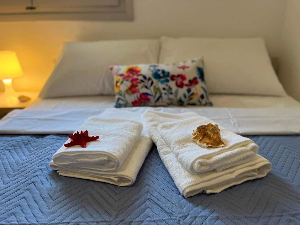 a bed with towels and a maple leaf on it at Holiday House Ermionida in Thermisía
