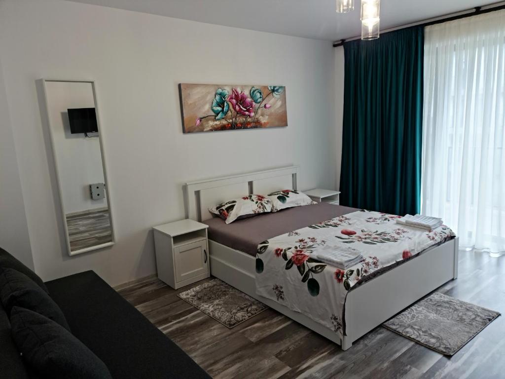 ein Schlafzimmer mit einem Bett und einem Sofa in einem Zimmer in der Unterkunft APARTAMENT SPLEND'OR No7 ALBA IULIA in Alba Iulia