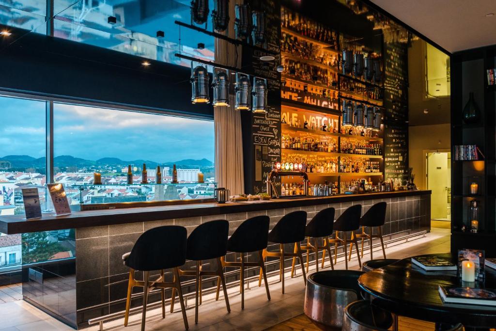 a bar with chairs and a view of a city at Octant Ponta Delgada in Ponta Delgada