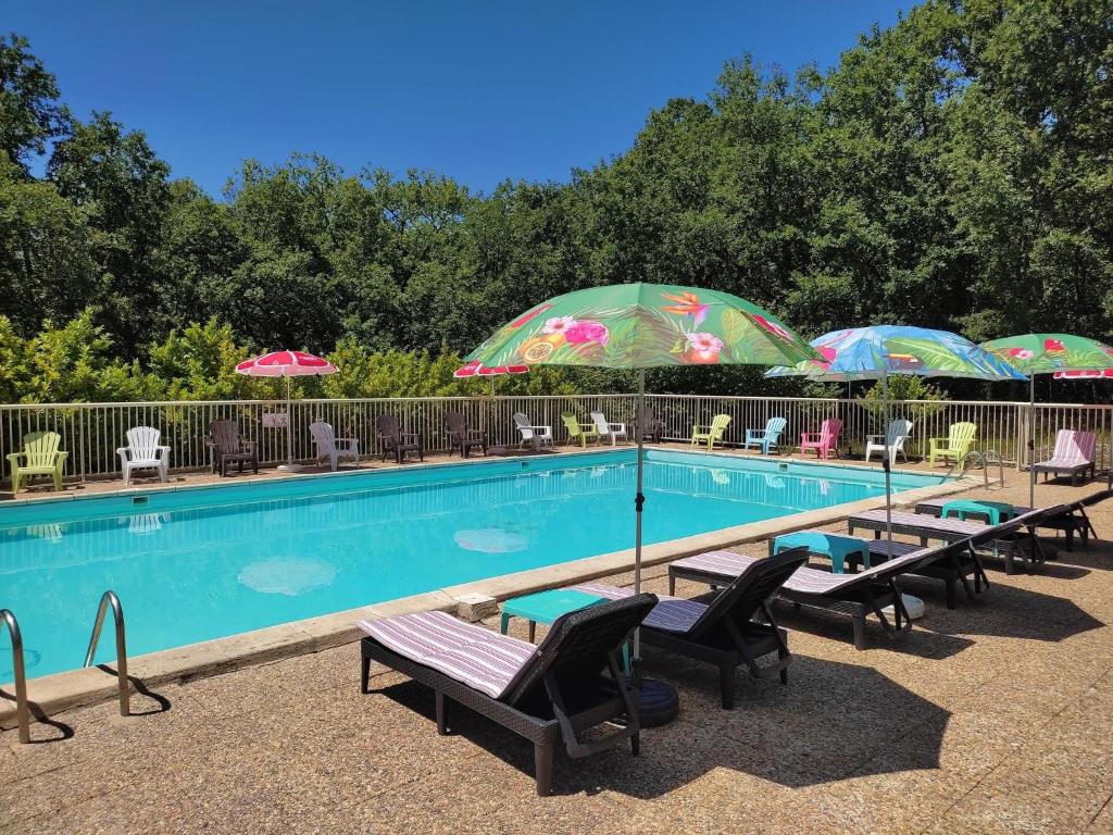 a swimming pool with chairs and umbrellas and umbrellas at Kamea Club La Gironie in Turenne