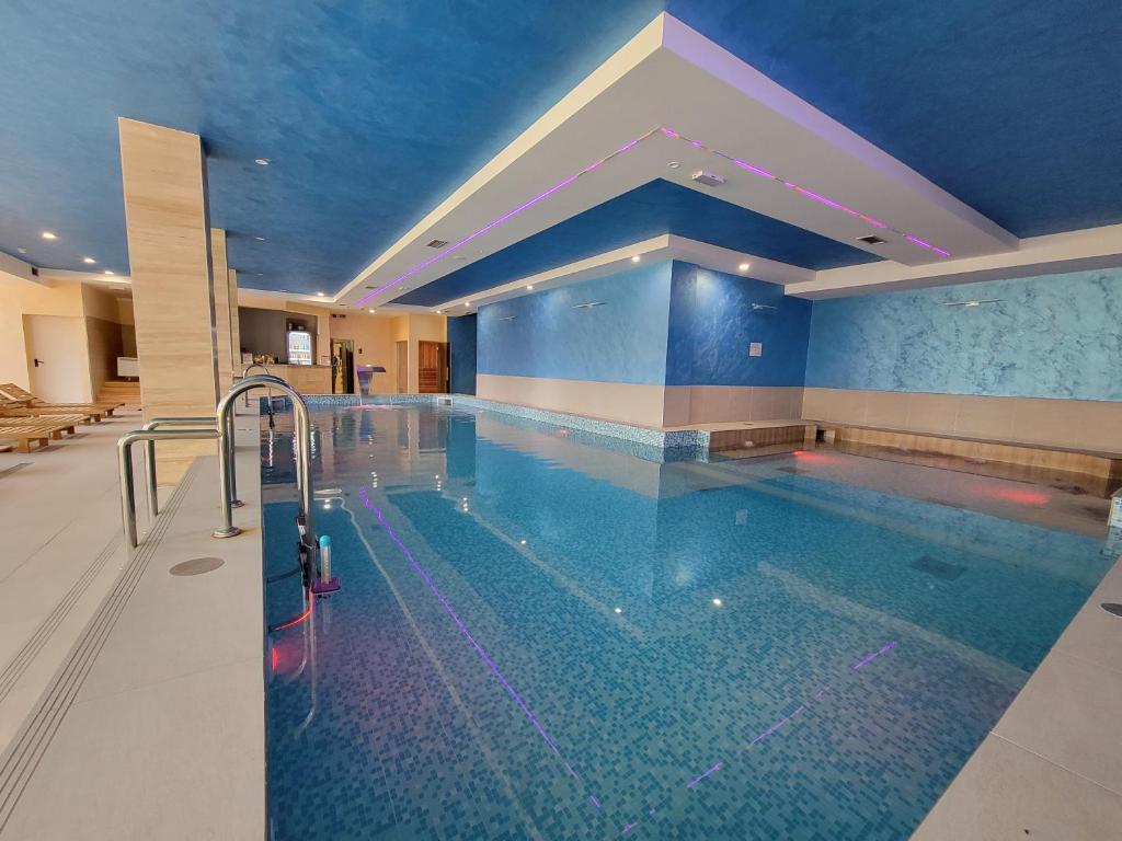 a large swimming pool in a hotel with blue walls at Goldview Apartmani in Zlatibor
