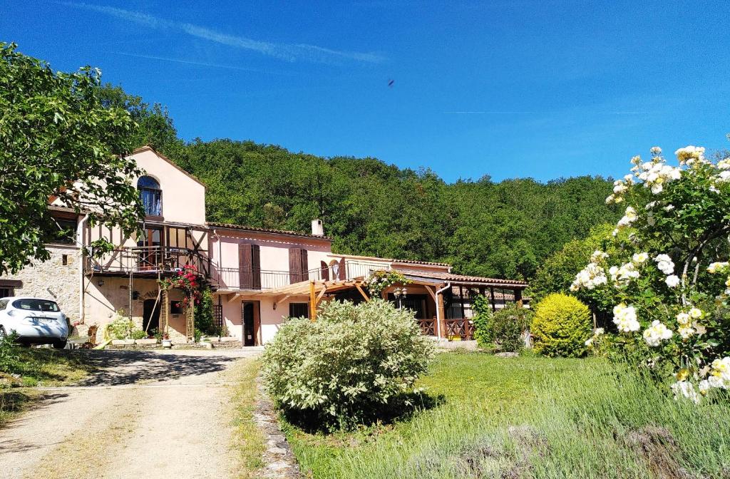 a large house with a car parked in front of it at Métairie de Lamourade - Un écrin de nature sereine in Saint-Ferriol