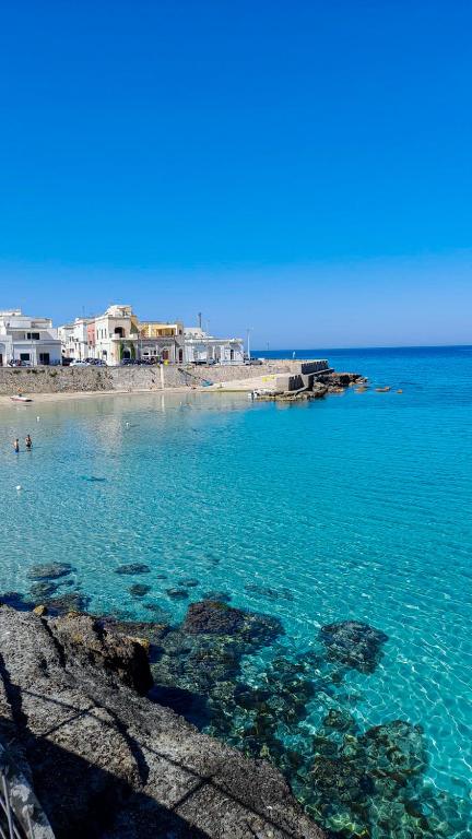 a view of a beach with blue water and buildings at LaVí - Splendido appartamento sul mare in Nardò
