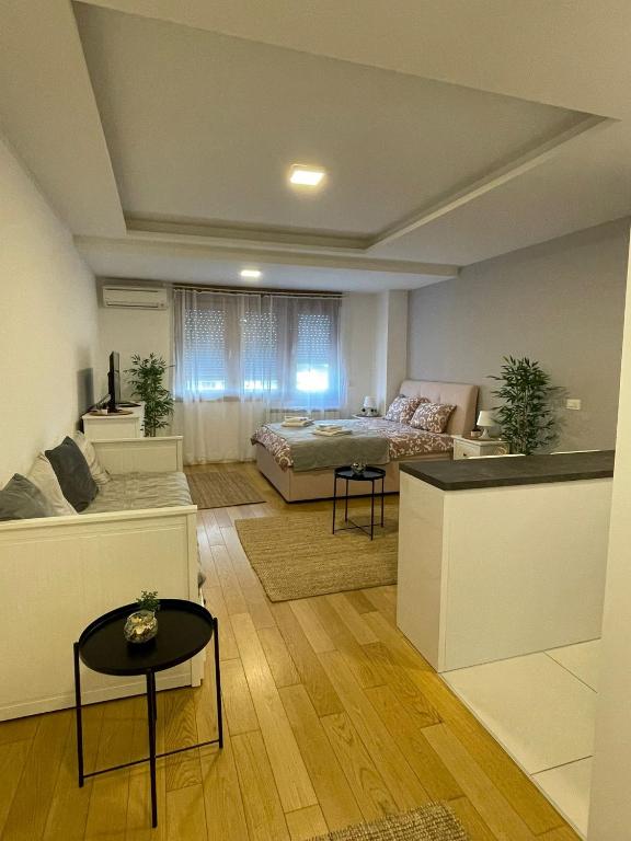 un ampio soggiorno con un letto e un divano di Manhattan apartman A blok a Novi Beograd