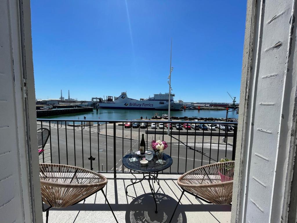 uma varanda com mesa e cadeiras e um navio de cruzeiro em "L'ancre" Studio Perret Pleine vue mer em Le Havre