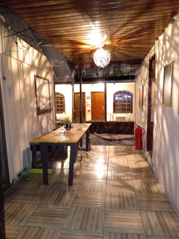 a hallway with a wooden table in a house at Pousada do Arthur in Ilha do Mel