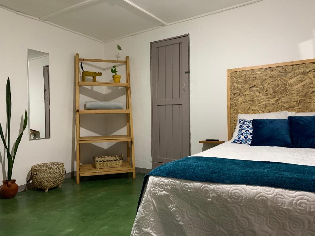 um quarto com uma cama e uma estante de livros em Chirris Hostel em San Juan La Laguna