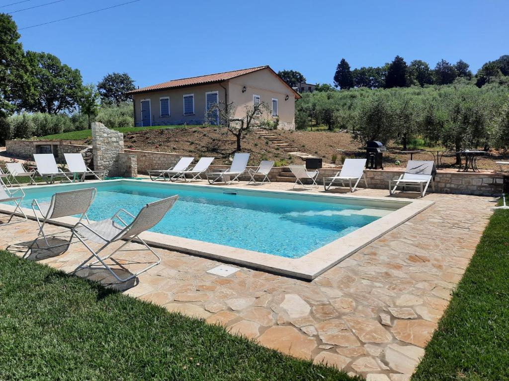 a swimming pool with lounge chairs and a house at Agriturismo Pane e Olio in Todi