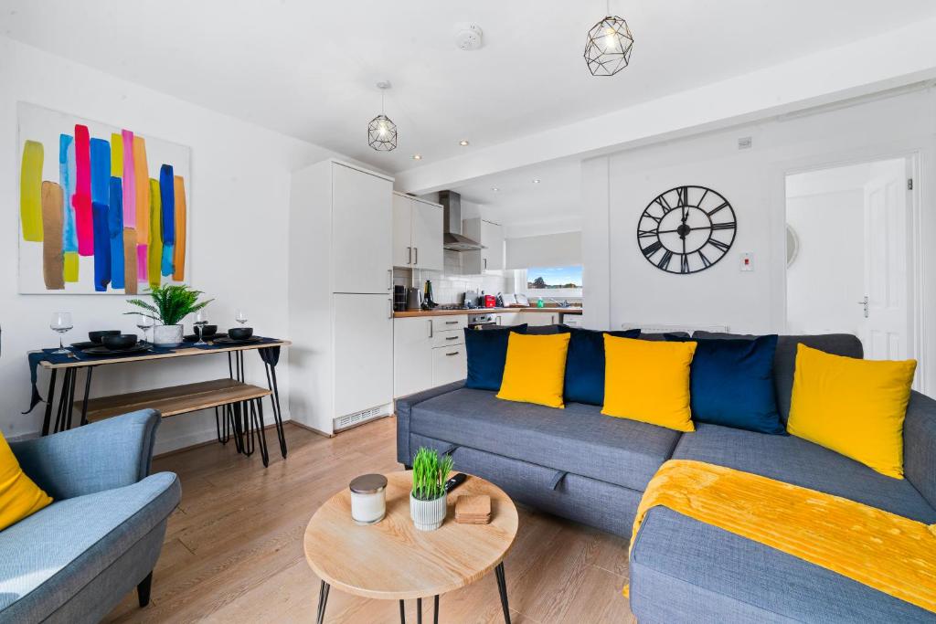 salon z niebieską kanapą i żółtymi poduszkami w obiekcie Village Cwtch Whitchurch 2 Bedroom Apartment w Cardiff