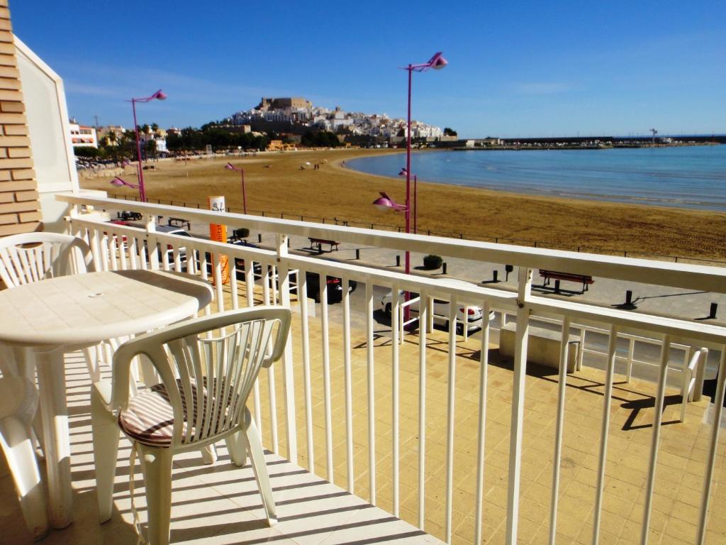 a balcony with a table and chairs and a beach at Bertur Forner in Peniscola