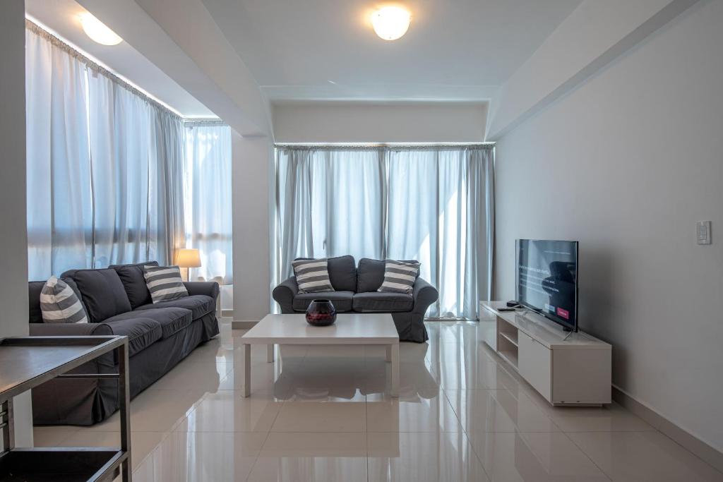 sala de estar con sofá y TV en Brand New Harmony Apartment with Pool and Gym in La Julia, en Santo Domingo