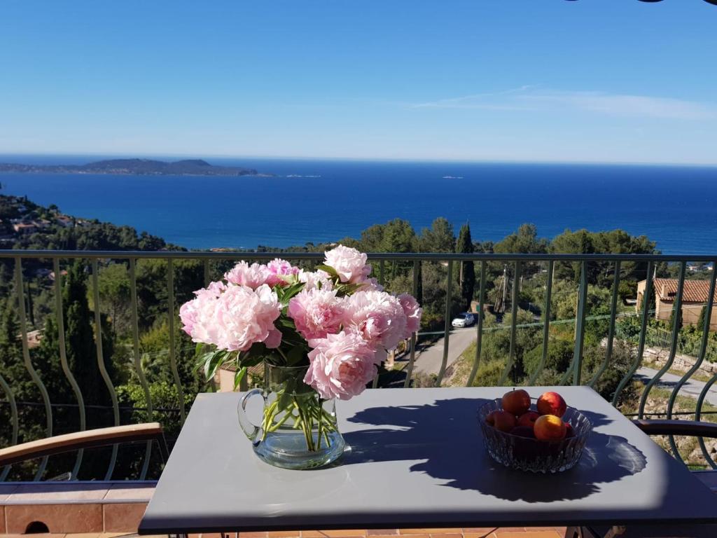 un jarrón de flores rosas y una cesta de fruta en una mesa en Villa Simone, en Carqueiranne