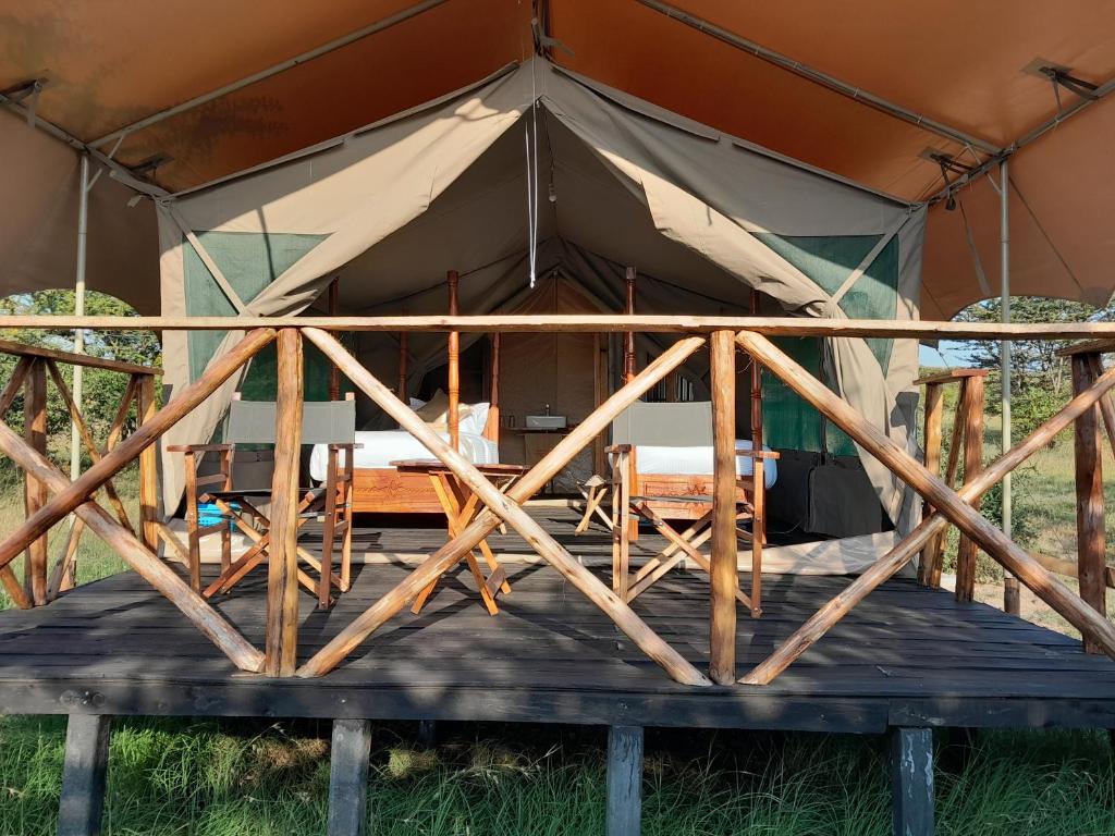 Sekenani的住宿－Tayari Luxury Tented Camp - Mara，帐篷内配有桌椅