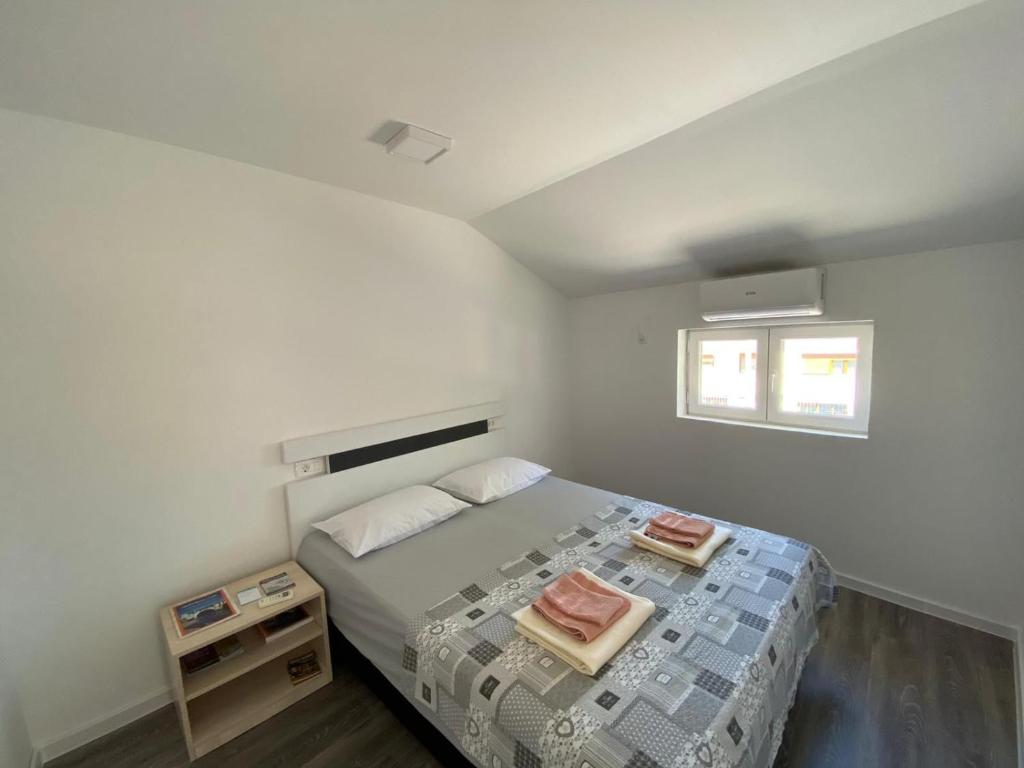een slaapkamer met een bed met twee handdoeken erop bij TIRYAKI in Mostar