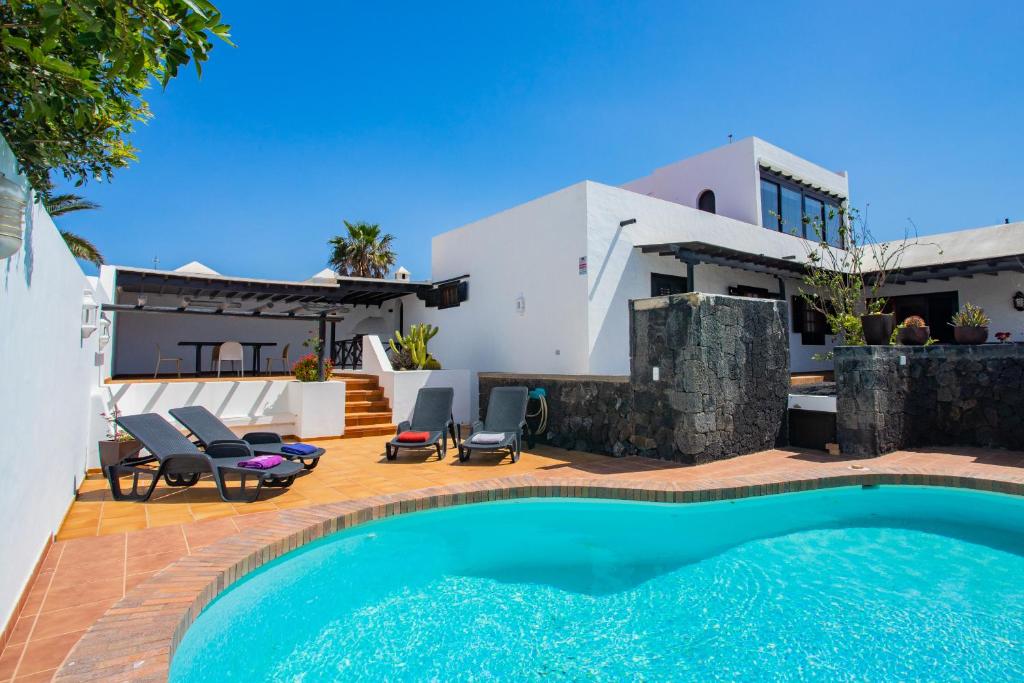 a villa with a swimming pool and a house at Casa Seara Piscina, Wifi y 400 metro de la playa, in Arrecife