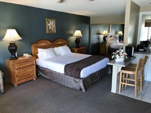 a bedroom with a large bed and a desk with a bed sidx sidx sidx sidx at Indian Palms Country Club in Indio