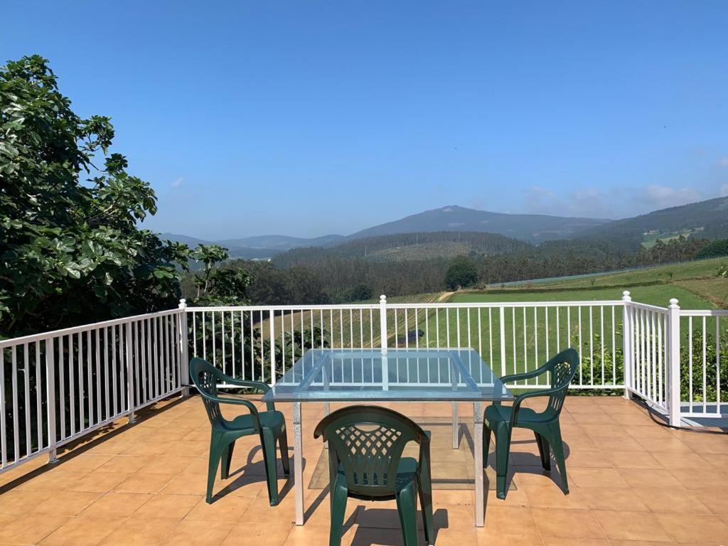 a table and chairs on a deck with a view at Casa ferreiro in Ribadeo