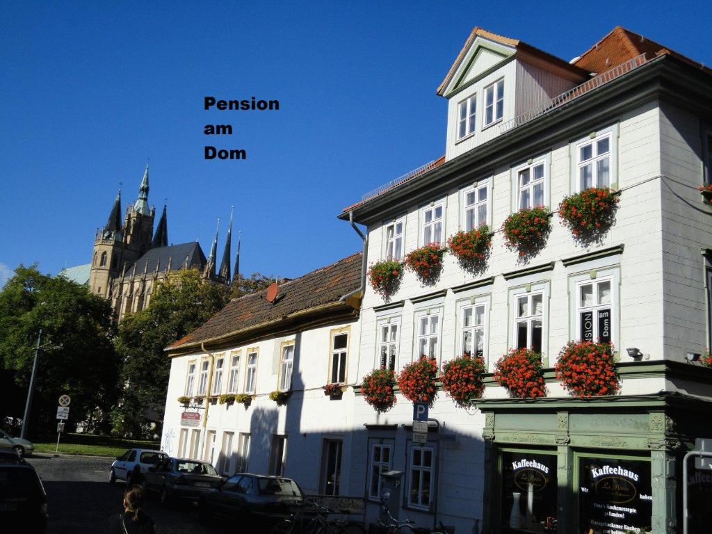 un edificio bianco con piante sul lato di Pension am Dom a Erfurt