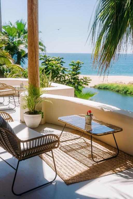 a patio with a table and chairs and the ocean at Villas La Mar - Adults 15 plus in Todos Santos