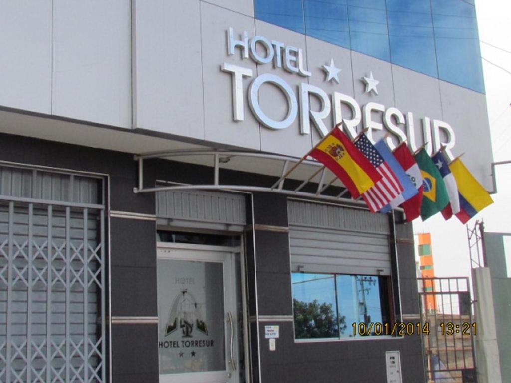 a hotel topless with flags in front of a building at Hotel Torresur Tacna in Tacna