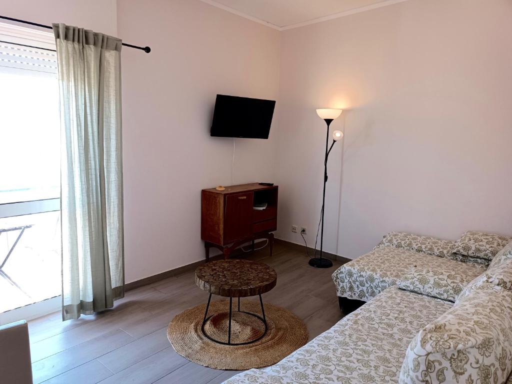 uma pequena sala de estar com uma cama e uma televisão em Alagoa Apartment 3 em Faro