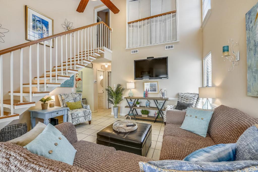 a living room with couches and a staircase at Flip Flop Inn by Book That Condo in Panama City Beach