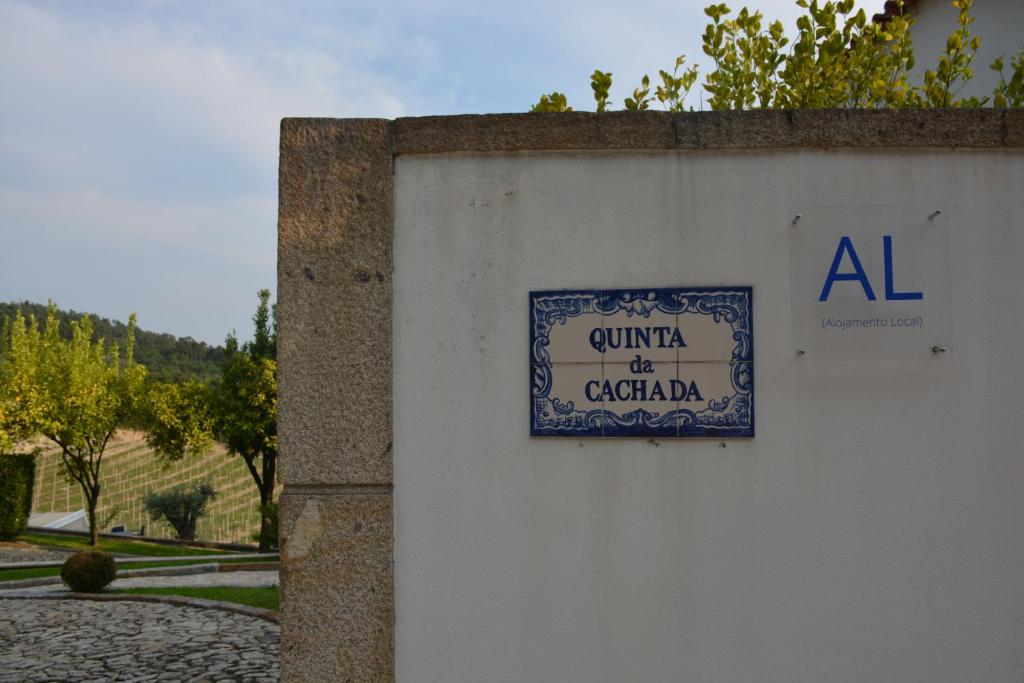 un cartello sul lato di un muro di Quinta da Cachada a Moure