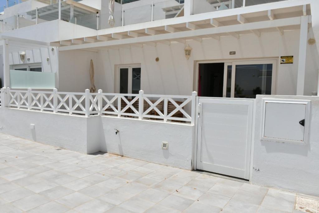 Una casa blanca con una puerta blanca y suelo de baldosas en Flower Beach 14, en San Bartolomé