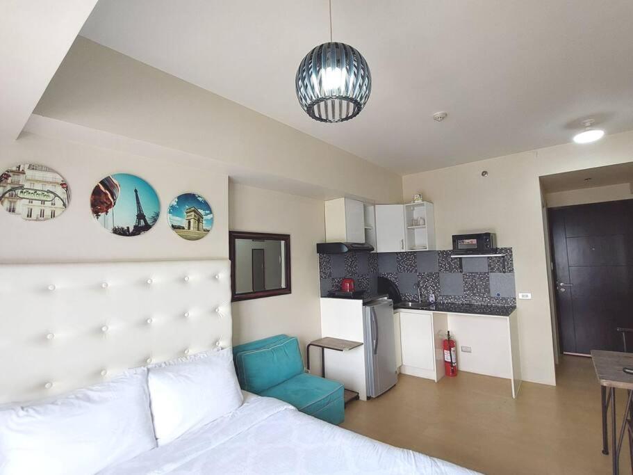 a bedroom with a white bed and a blue chair at Home in the Heart of Cagayan De Oro City in Cagayan de Oro