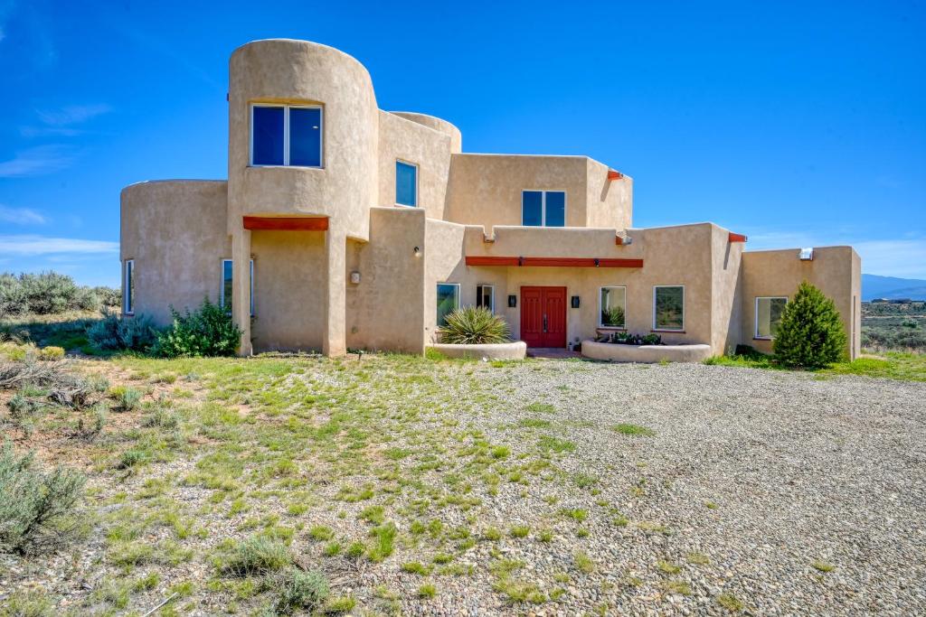 ein Haus in der Wüste mit einer roten Tür in der Unterkunft Southwest Stunner in Ranchos de Taos