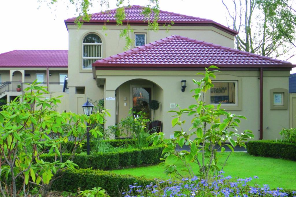 uma casa com um jardim em frente em Lorenzo Motor Lodge em Christchurch