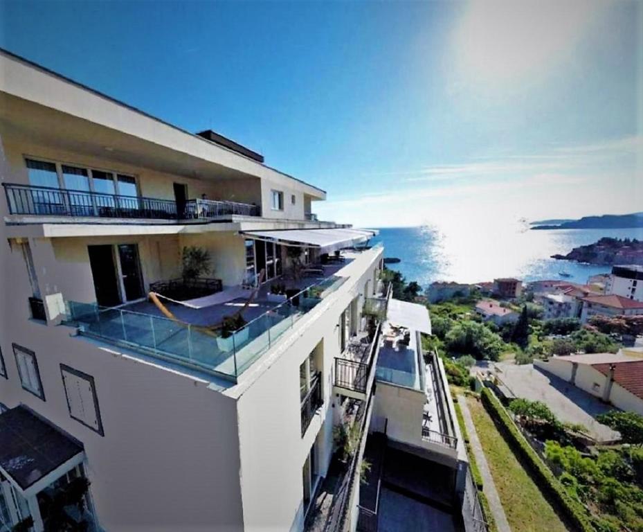 a white building with a view of the ocean at Vertmont Villa in Sveti Stefan