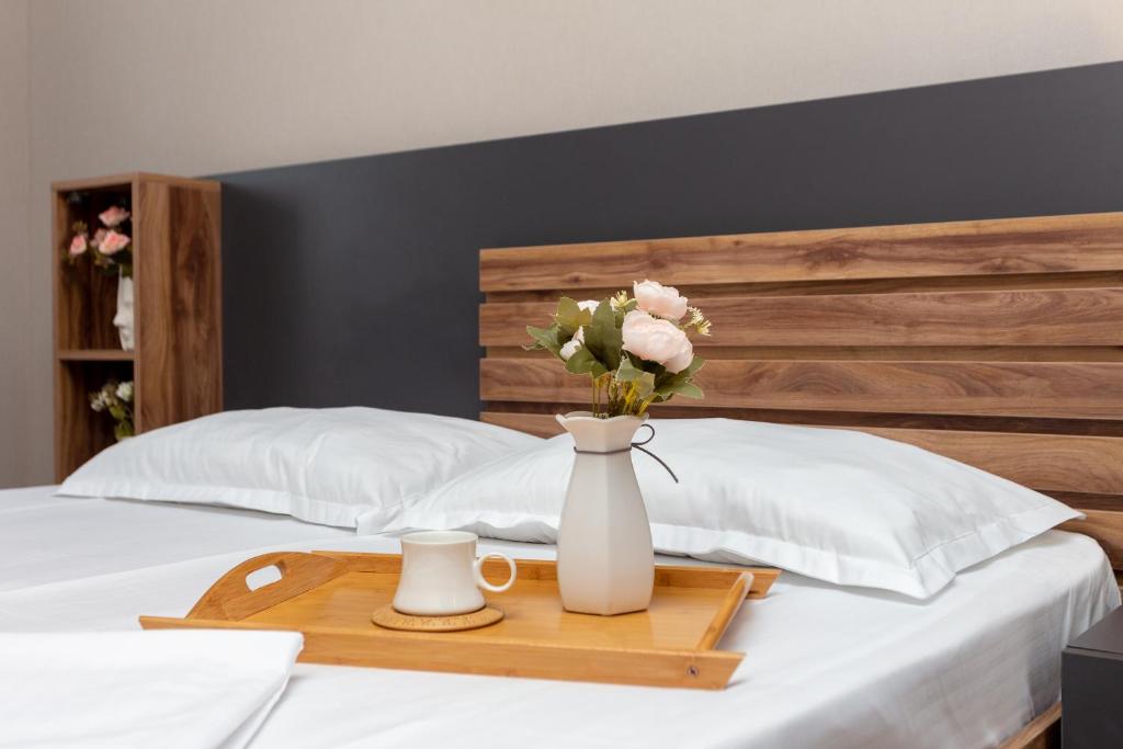 a tray with a vase of flowers on a bed at Saburtalo Apartment in Tbilisi City