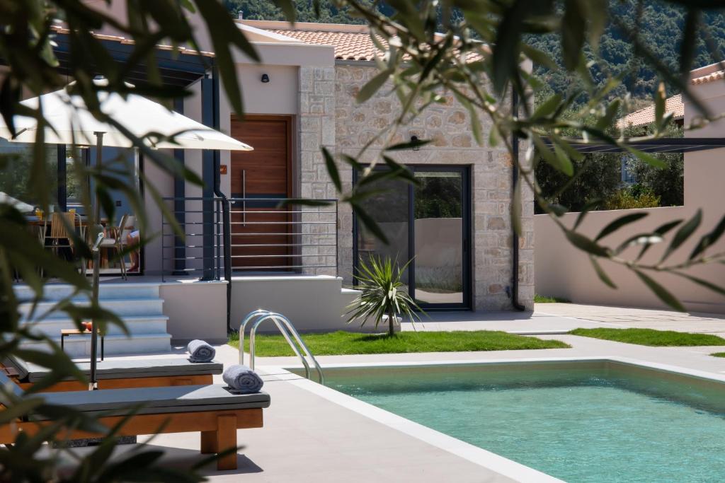 a swimming pool in front of a house at RIZOMATA LUXURY VILLAS in Lefkada