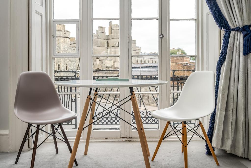 two white chairs and a table in front of a window at Stunning 1Bd with Castle View in Windsor