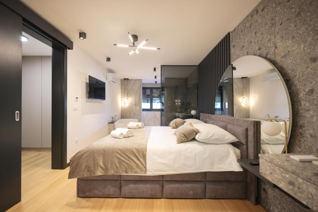 sypialnia z dużym łóżkiem z dużym lustrem w obiekcie LL luxury penthouse on sea w Bibinje