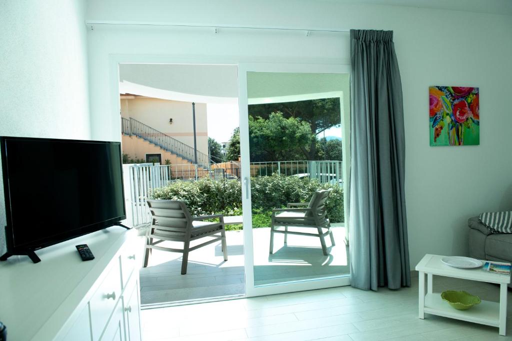 sala de estar con puerta corredera de cristal que da a un patio en Casa Francesca, en Golfo Aranci