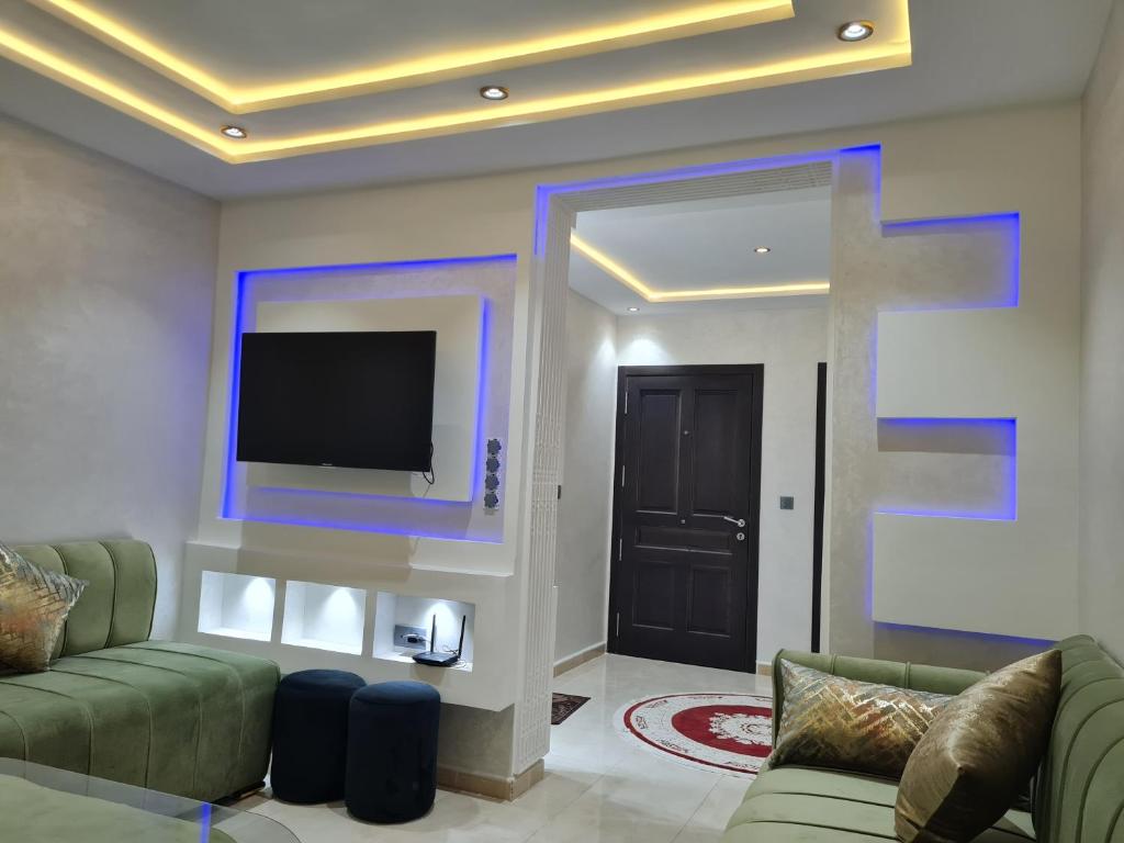 - un salon avec un canapé et une télévision murale dans l'établissement Appartement a Nador, à Nador
