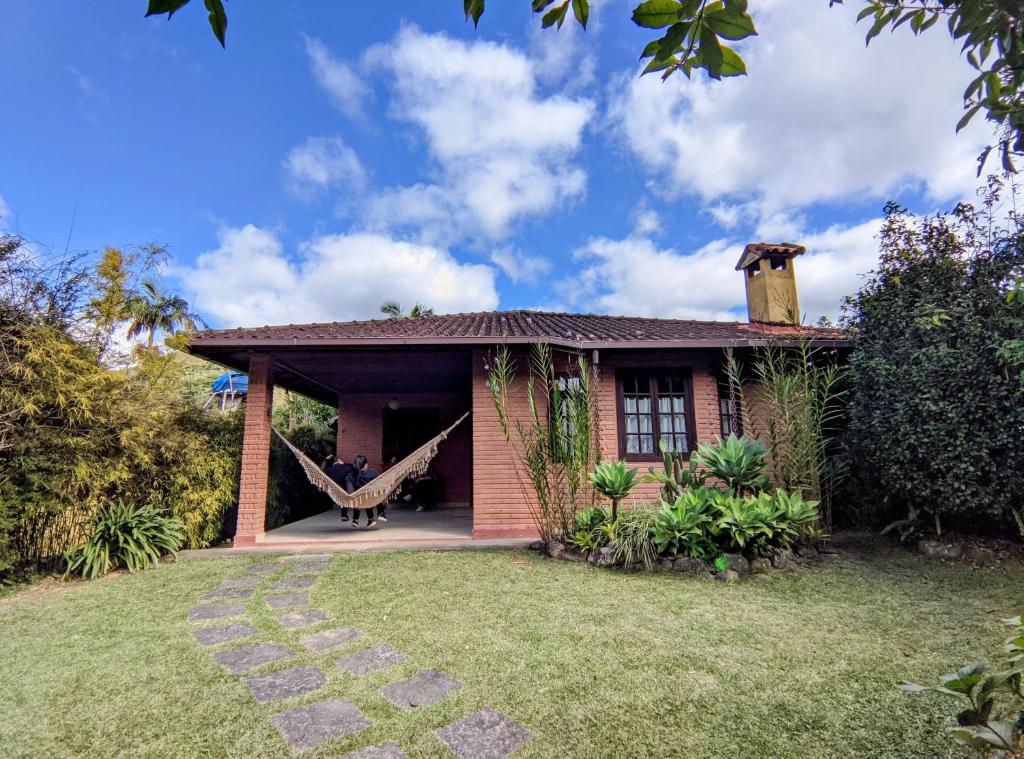 una casa con una hamaca en el patio trasero en toda paz do universo, en Nova Friburgo