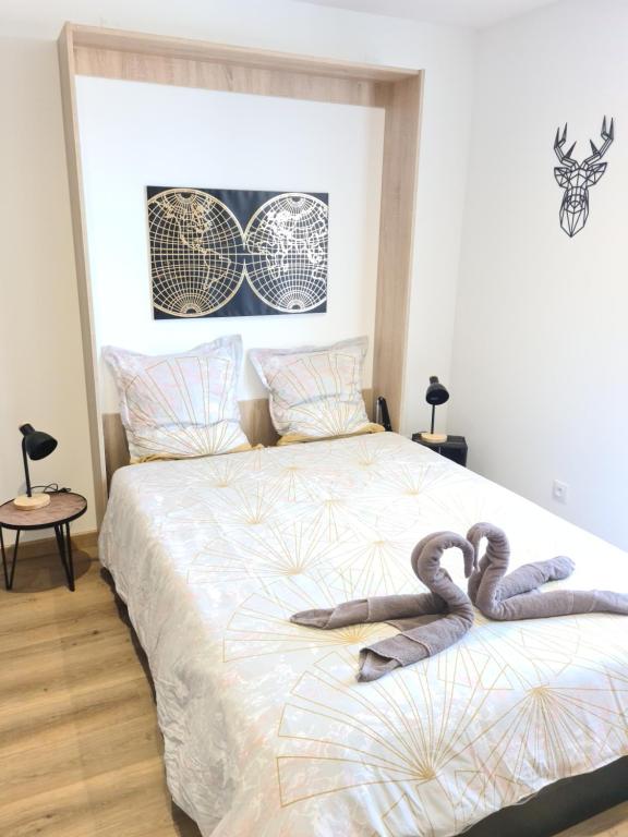 une chambre avec un lit avec deux cygnes dessus dans l'établissement La P'tite Bas-Rivière, à Blois