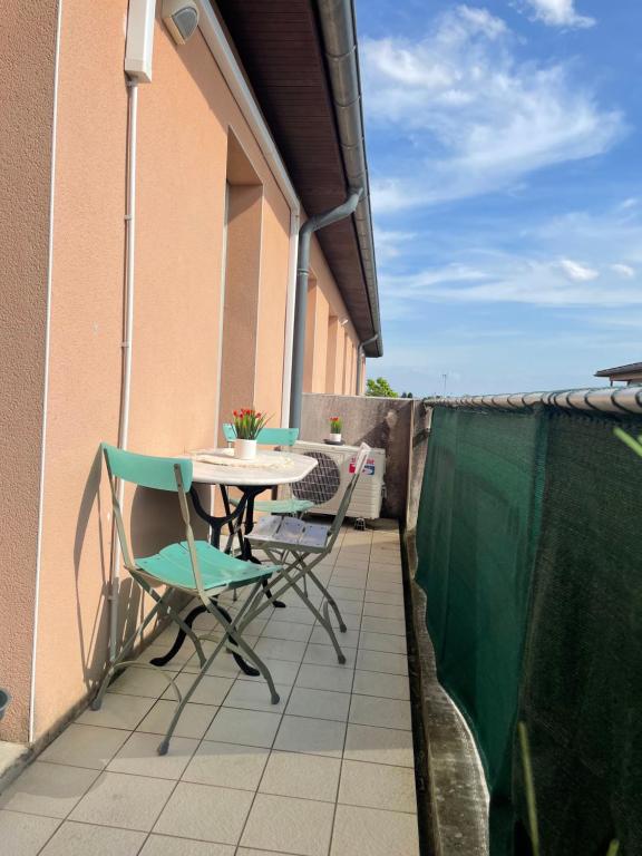 een patio met een tafel en stoelen op een balkon bij Appart'Bohème *CLIM*PARKING*WIFI*CONFORT in Blagnac