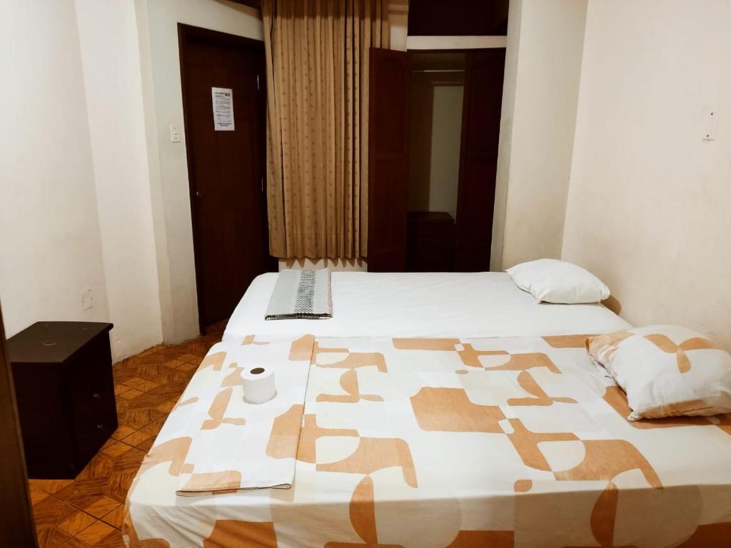 um quarto de hotel com duas camas e uma colcha em Hostal Muchik em Chiclayo