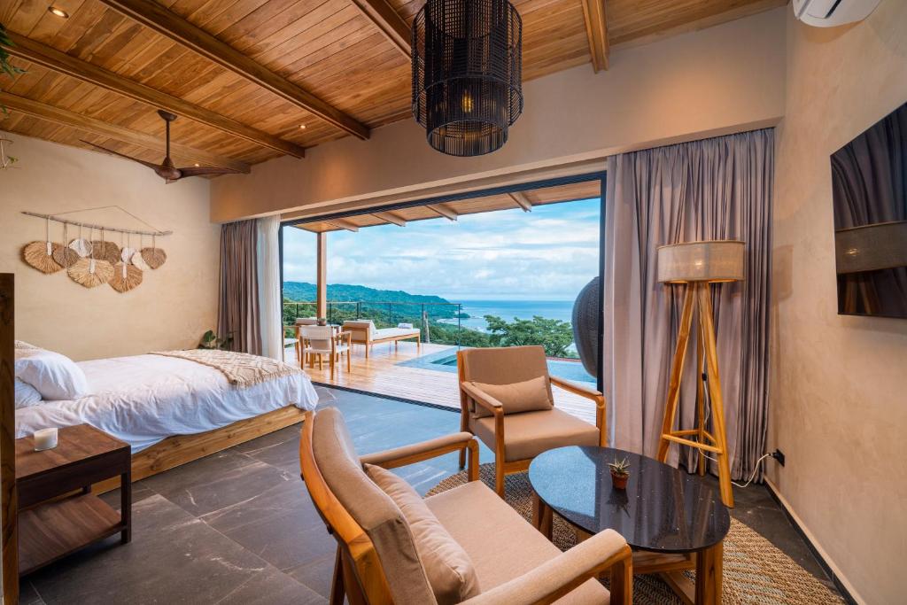 a bedroom with a bed and a view of the ocean at LALOON Luxury Suites - Adults Only in Santa Teresa Beach