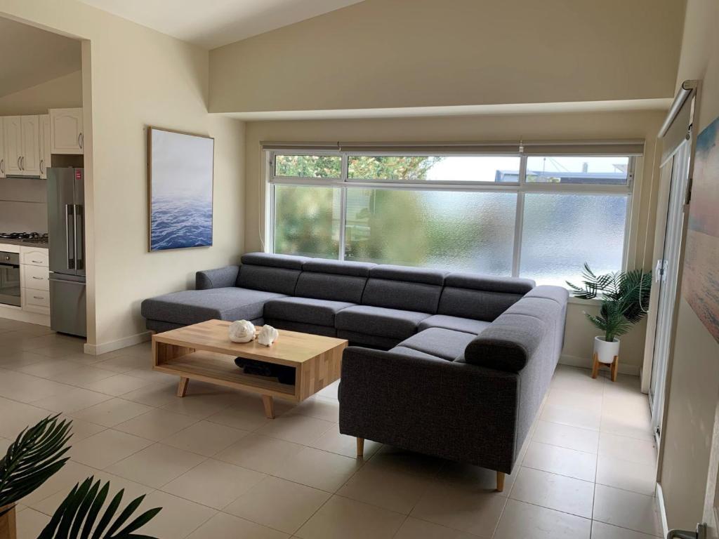 Una sala de estar con un sofá y una mesa de café. en Contemporary On Cuttriss - Inlet Side, en Inverloch