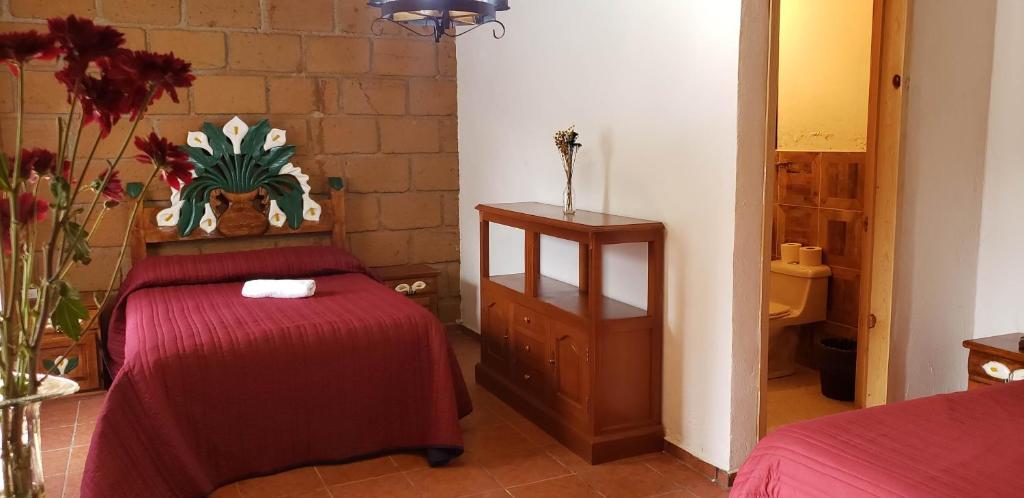 - une chambre avec un lit doté d'un couvre-lit rouge dans l'établissement Hotel Jardin Rincon de las Estrellas, à Velasco