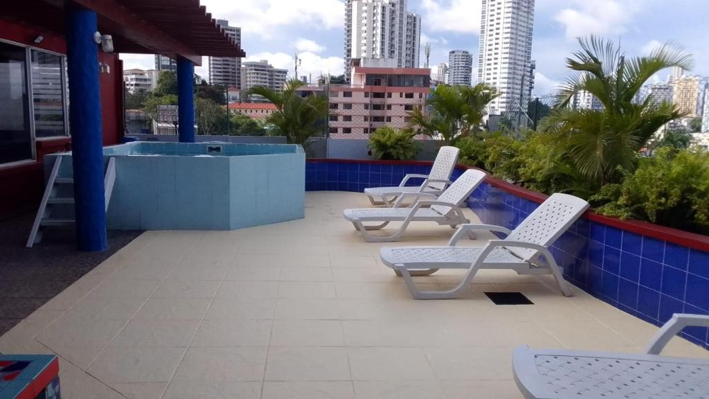 a row of white chairs sitting on a roof at Hotel California Panama in Panama City