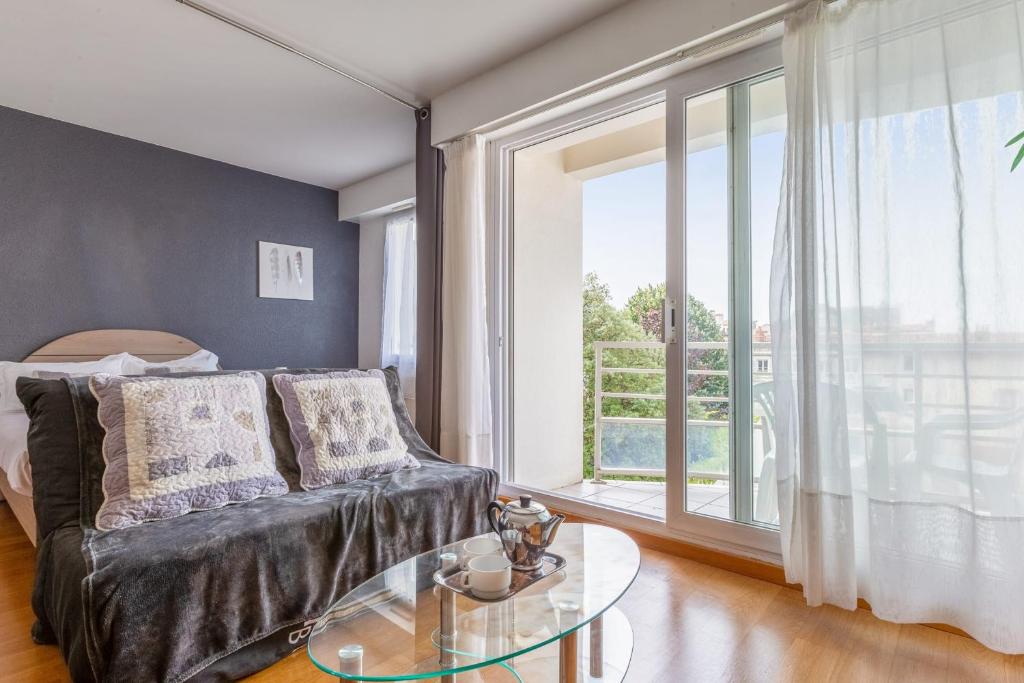 Appartement Petit coin de paradis - Welkeys في لا روشيل: غرفة معيشة مع أريكة وطاولة زجاجية