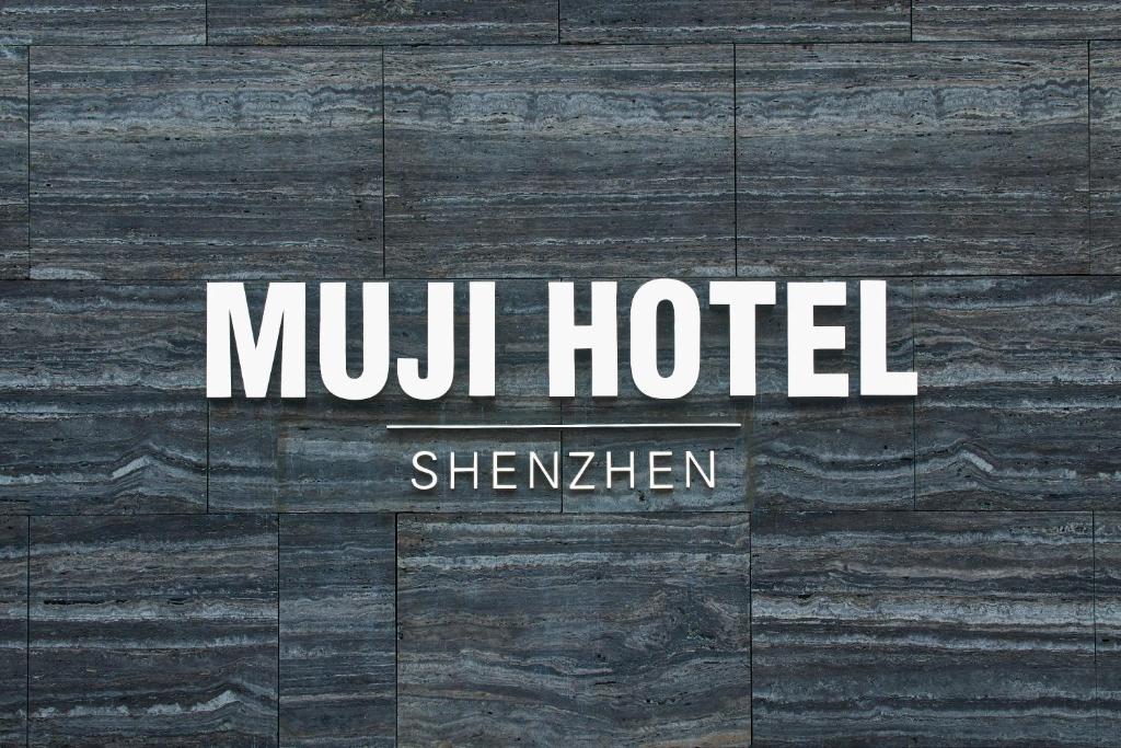 ein Schild für ein Hotel auf einem Holzboden in der Unterkunft MUJI HOTEL SHENZHEN in Shenzhen