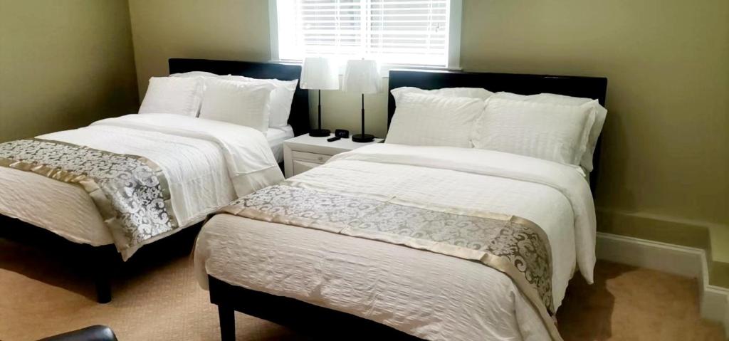 - une chambre avec 2 lits avec des draps blancs et une fenêtre dans l'établissement Beautiful Private Room in BlueBack BeachFront, à Nanaimo